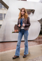 Student standing in front of the B logo statue